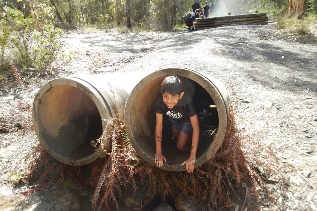 Scout crawling through pipe